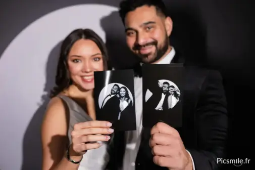 Couple de mariés utilisant un photobooth lors d’un mariage à Lens. La borne photo Picsmile permet aux invités de prendre des photos souvenirs avec impressions instantanées et partage numérique pour une animation originale et élégante lors des mariages et événements.