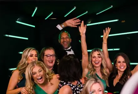 Groupe de participants profitant du Photobooth Vogue dans un tunnel lumineux LED lors d'un événement